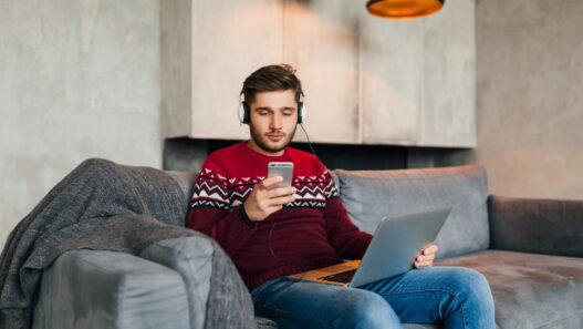 a girl sitting on a couch and using internet on his phone