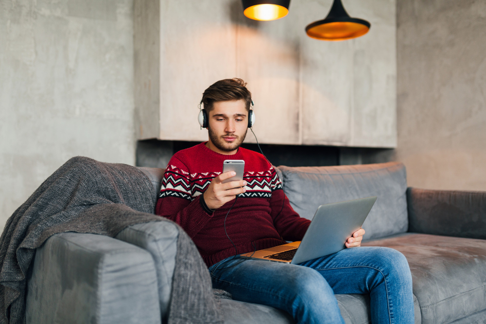 a girl sitting on a couch and using internet on his phone